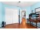 Bedroom with hardwood floors, white double closets, light blue walls, and view of hallway at 65 Ashland Grove Ct, Sharpsburg, GA 30277