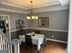 Traditional dining room featuring a chandelier, half-wall paneling, and hardwood floors at 65 Ashland Grove Ct, Sharpsburg, GA 30277