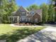Charming two-story home featuring stone accents, a welcoming front porch, and a meticulously landscaped front yard at 65 Ashland Grove Ct, Sharpsburg, GA 30277
