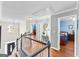 Hallway featuring hardwood floors, stairs with white railing, arched window, and entry to bedroom at 65 Ashland Grove Ct, Sharpsburg, GA 30277