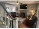 Comfortable living room featuring a stone fireplace, ceiling fan, and cozy brown furniture at 65 Ashland Grove Ct, Sharpsburg, GA 30277