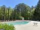 Community swimming pool with lounge area surrounded by lush greenery, providing a relaxing and inviting atmosphere at 65 Ashland Grove Ct, Sharpsburg, GA 30277