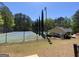 Community tennis court surrounded by lush trees, offering a secluded and serene recreational space at 65 Ashland Grove Ct, Sharpsburg, GA 30277