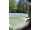 Well-maintained tennis court featuring a blue and green surface, enclosed by a fence, and surrounded by trees at 65 Ashland Grove Ct, Sharpsburg, GA 30277
