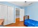 Light blue bedroom with wood floors, large closet, and view to the upstairs hall at 65 Ashland Grove Ct, Sharpsburg, GA 30277