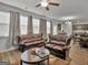 Bright living room featuring classic leather sofas, large windows, and hardwood flooring at 340 Layfield Dr, Jonesboro, GA 30238