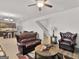 Cozy living room with a leather sofa and chair, featuring modern lighting and a staircase in the background at 340 Layfield Dr, Jonesboro, GA 30238