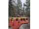 Manicured front yard featuring a birdbath and treed landscape at 5207 Sw West Shore Dr, Conyers, GA 30094