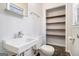Classic bathroom with a pedestal sink, toilet, and storage shelves next to the toilet at 1436 Heritage Court Ct, Villa Rica, GA 30180