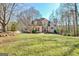 View of the inviting two-story home showcasing the lawn and mature trees in a landscaped front yard at 417 Plantain Ter, Peachtree City, GA 30269