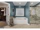 Beautiful blue bathroom featuring a large tub and stylish glass-enclosed shower at 605 Clearwater Ct, Mcdonough, GA 30252