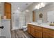 Bathroom features wood-look floors, oak vanity, walk-in shower, and neutral decor at 605 Clearwater Ct, Mcdonough, GA 30252