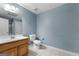 Bathroom with wood vanity, white toilet, and tile flooring, showcasing a clean and functional design at 605 Clearwater Ct, Mcdonough, GA 30252