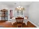 Bright dining room with hardwood floors, a decorative chandelier, a table, and a view of the outside at 605 Clearwater Ct, Mcdonough, GA 30252