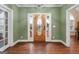 Inviting foyer with hardwood floors, green walls and a decorative wooden front door with sidelights at 605 Clearwater Ct, Mcdonough, GA 30252