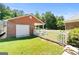 Charming garage with white door and brick exterior, complemented by a white picket fence and lush green lawn at 605 Clearwater Ct, Mcdonough, GA 30252