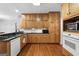 Spacious kitchen with wood cabinets, black countertops, stainless steel appliances and hardwood floors at 605 Clearwater Ct, Mcdonough, GA 30252