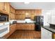 View of the kitchen with light wood cabinets, granite countertops, and black appliances at 605 Clearwater Ct, Mcdonough, GA 30252