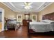 View of the spacious primary bedroom with a tray ceiling, hardwood floors, and a comfortable seating area at 605 Clearwater Ct, Mcdonough, GA 30252