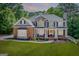 Charming two-story home features a brick and stone facade, covered porch, landscaped yard, and meticulous design at 6690 Bridge Brook Ovlk, Cumming, GA 30028