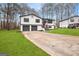 Suburban home featuring a two-car garage, manicured lawn, and a charming red front door at 7012 Winter Woods Ct, Morrow, GA 30260