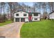 Charming home featuring a well-manicured lawn, updated exterior, and a bright red front door at 7012 Winter Woods Ct, Morrow, GA 30260