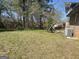 Large backyard with healthy grass, trees, and partial fence at 6861 Wendy Jean Dr, Morrow, GA 30260