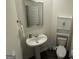 Functional half bathroom with pedestal sink, toilet, and convenient cabinet storage at 142 Hampton Cir, Mcdonough, GA 30253