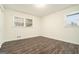 An empty bedroom showcasing wood-look floors and bright natural light through two windows at 5595 Richland Dr, Douglasville, GA 30135