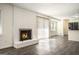 Cozy living room area with a white brick fireplace, hardwood floors, and an open view to the kitchen at 5595 Richland Dr, Douglasville, GA 30135