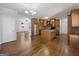 Open kitchen with island, tile backsplash, hardwood floors, and an open floor plan leading to other spaces at 10067 Freeman Ct, Jonesboro, GA 30236