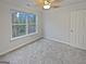 Bedroom with a ceiling fan, carpet flooring, large window, and a closet door at 483 Fairlane Nw Cir, Atlanta, GA 30331