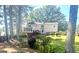 Spacious backyard featuring lush greenery, mature trees, and a two-story home with a screened-in porch at 105 Windridge Dr, Fayetteville, GA 30215