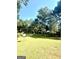 Wide angle shot of the private backyard with a satellite dish and mature trees providing shade and privacy at 105 Windridge Dr, Fayetteville, GA 30215