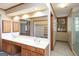 Bright bathroom featuring a double vanity, large mirror, and an open walk-in closet for ample storage at 105 Windridge Dr, Fayetteville, GA 30215