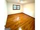 Empty bedroom with gleaming wood floors and plenty of natural light from the window at 105 Windridge Dr, Fayetteville, GA 30215