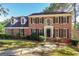 Charming two-story brick home featuring black shutters, a manicured lawn, and a welcoming front entrance at 105 Windridge Dr, Fayetteville, GA 30215