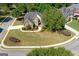 Aerial view of a well-maintained, landscaped property with mature trees, lush green lawns, and a circular driveway at 1500 Royce Dr, Locust Grove, GA 30248