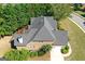 Aerial view showcases a well-maintained home with a shingled roof, manicured landscaping, and mature trees at 1500 Royce Dr, Locust Grove, GA 30248