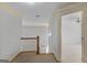 Hallway leading to a bedroom with a ceiling fan and neutral carpeting at 1500 Royce Dr, Locust Grove, GA 30248