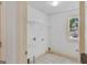 Bright laundry room featuring a utility sink, shelving, and a window offering natural light at 1500 Royce Dr, Locust Grove, GA 30248