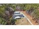 Aerial view of a home, metal shop building, and surrounding wooded acreage with a long driveway at 1185 Old Greenville Rd, Fayetteville, GA 30215