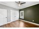 This bedroom features a horizontal wood accent wall, ceiling fan, wood floors, and closet at 1185 Old Greenville Rd, Fayetteville, GA 30215