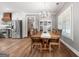 Open dining room showing a wooden table and chairs, chandelier, with kitchen and stainless steel fridge in background at 1185 Old Greenville Rd, Fayetteville, GA 30215