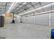 Spacious garage interior with concrete floors, roll-up doors, ceiling fans, and ample lighting at 1185 Old Greenville Rd, Fayetteville, GA 30215