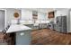 A stylish kitchen featuring white cabinets, sage lower cabinets, stainless steel appliances, and a rustic wood floor at 1185 Old Greenville Rd, Fayetteville, GA 30215