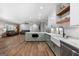 An open-concept view from a kitchen with stainless steel appliances and white cabinetry connecting to the living room at 1185 Old Greenville Rd, Fayetteville, GA 30215