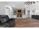 Cozy living room highlighting a brick fireplace with a mounted TV, leather furniture, and a ceiling fan at 1185 Old Greenville Rd, Fayetteville, GA 30215