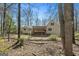 The back of the home has a covered porch, and a fenced yard filled with mature trees at 135 Flat Creek Ct, Fayetteville, GA 30214