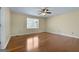 Sunny bedroom with a ceiling fan, hardwood floors, and a large window at 135 Flat Creek Ct, Fayetteville, GA 30214